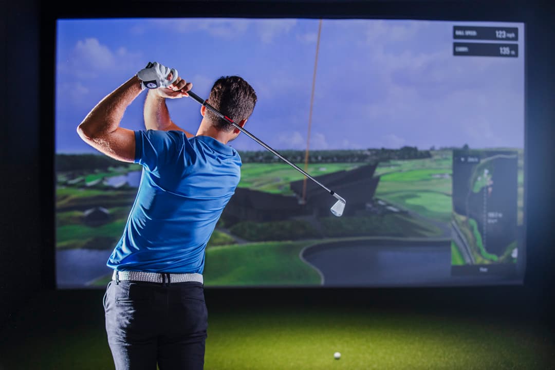 Spiller midt i sving foran Trackman simulator